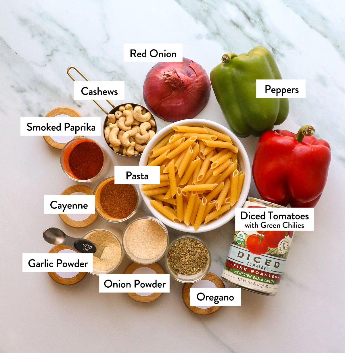 pasta, diced tomatoes, red onion, bell peppers, and spices labeled on a white surface.