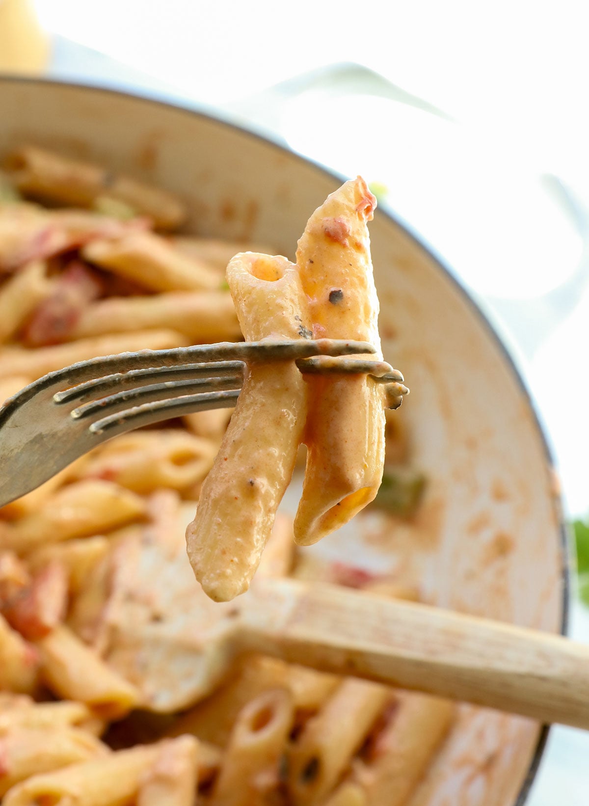 cajun pasta noodles on a fork to show creamy sauce.