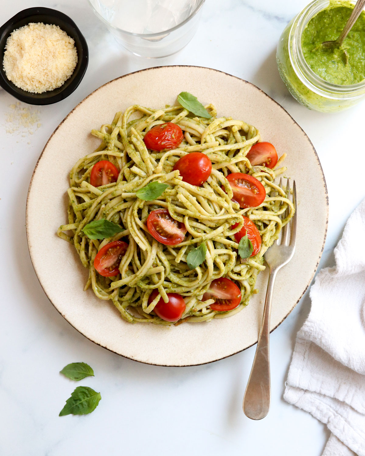 pesto pasta with tomatoes and fresh basil on plate