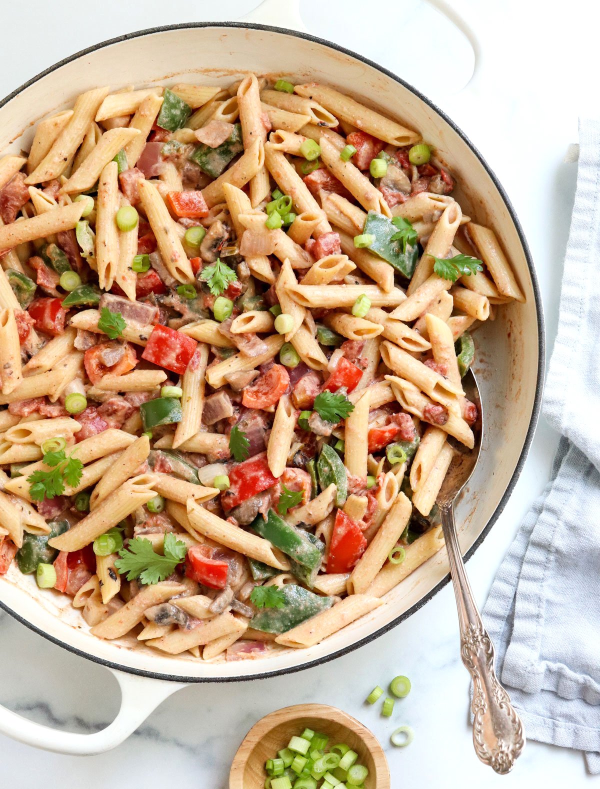 cajun pasta in white skillet with spoon