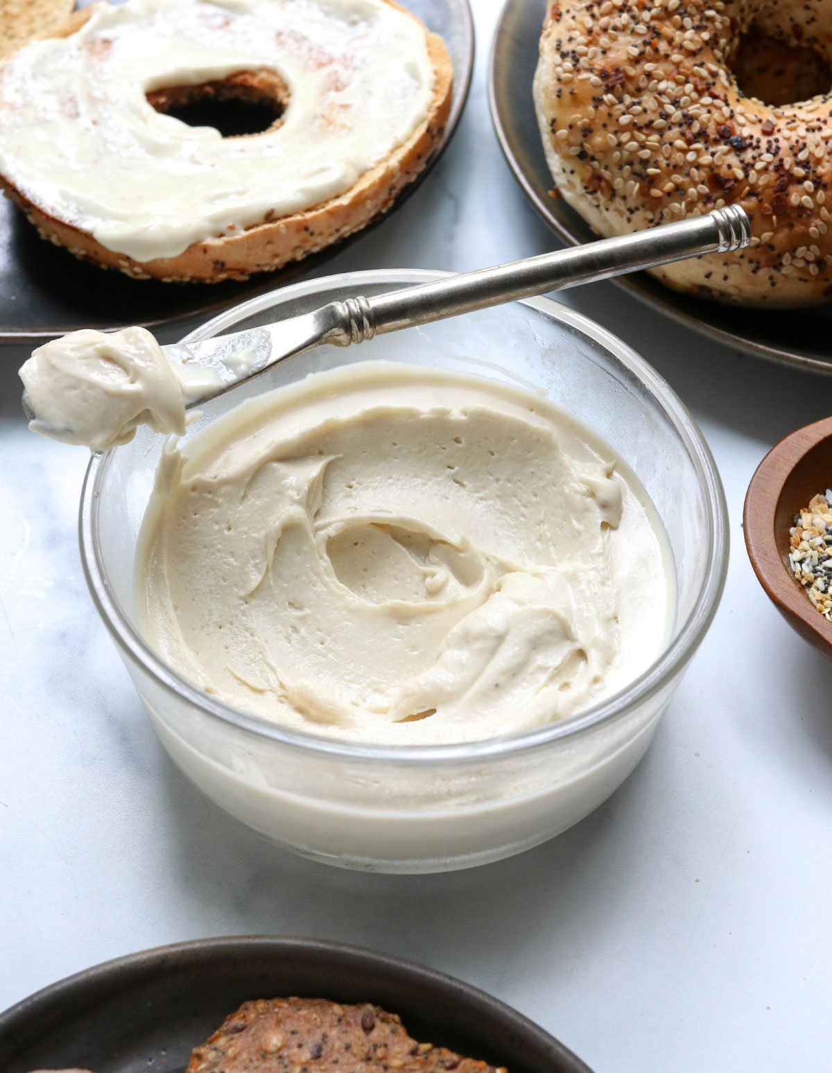 vegan cream cheese spread on half of a bagel