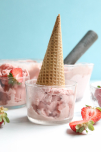 strawberry ice cream cone upside down in bowl