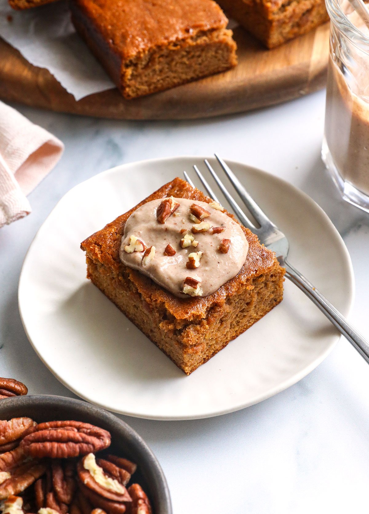 gluten-free pumpkin bar on a white plate with maple pecan glaze on top.