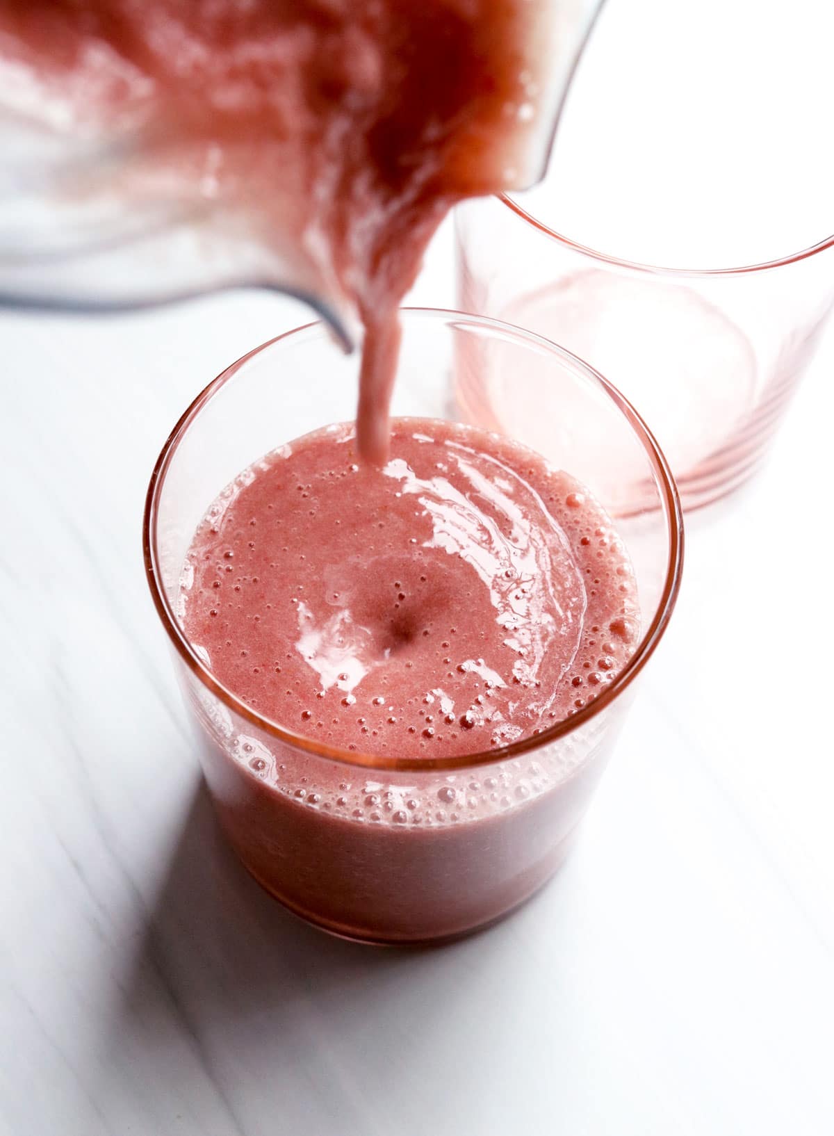 elderberry smoothie poured from blender into glass