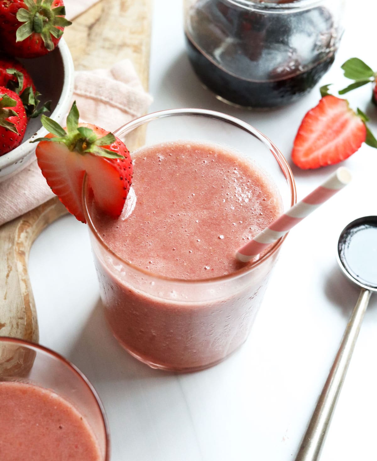 elderberry smoothie in glass with strawberry on top