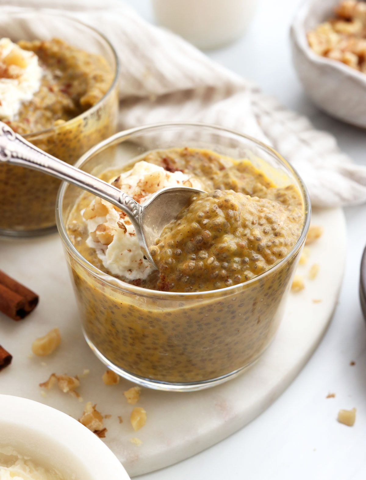 spoon scooping up some pumpkin chia pudding from a serving bowl