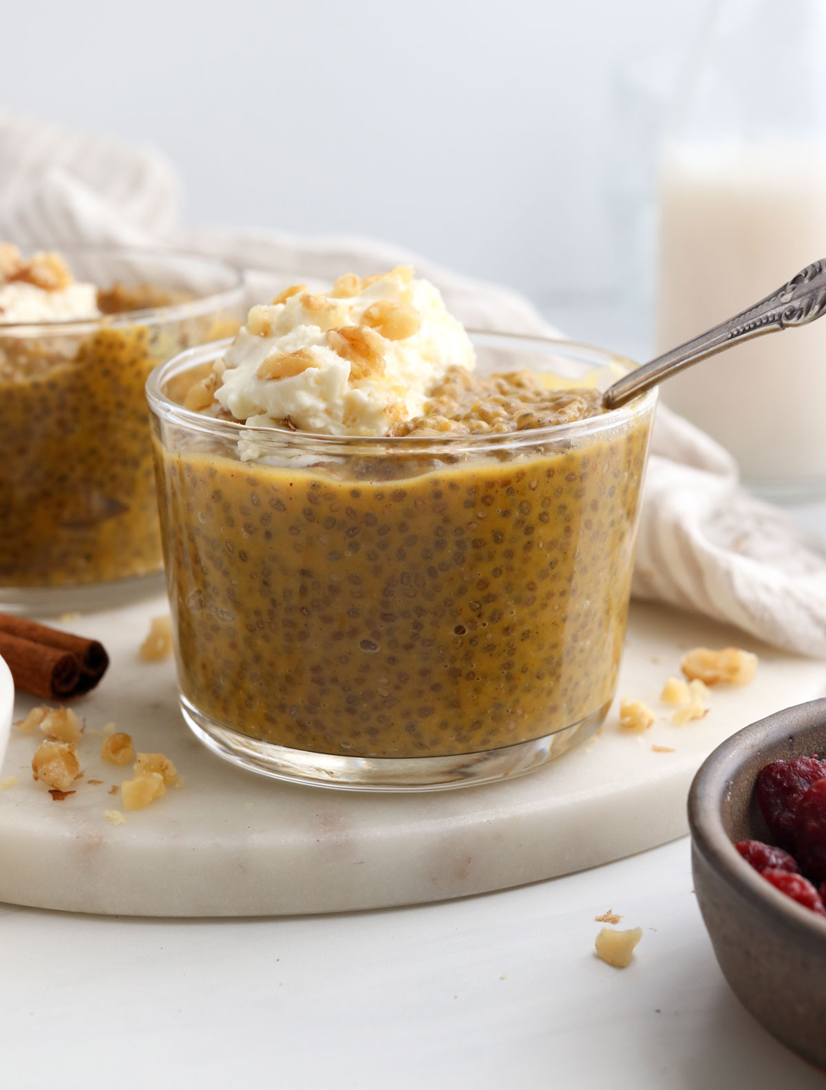 pumpkin chia pudding with whipped cream and walnuts on top