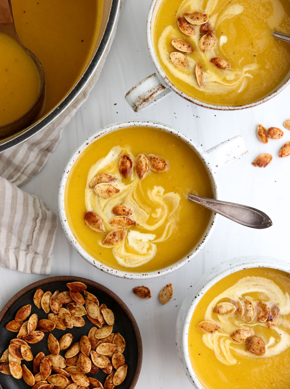 roasted pumpkin soup in mugs with pumpkin seeds on top