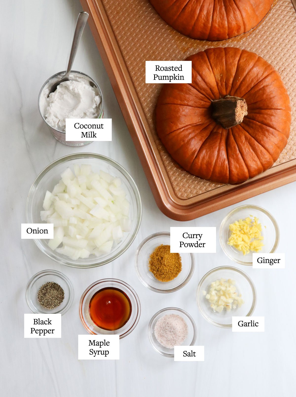 roasted pumpkin soup ingredients arranged on white table