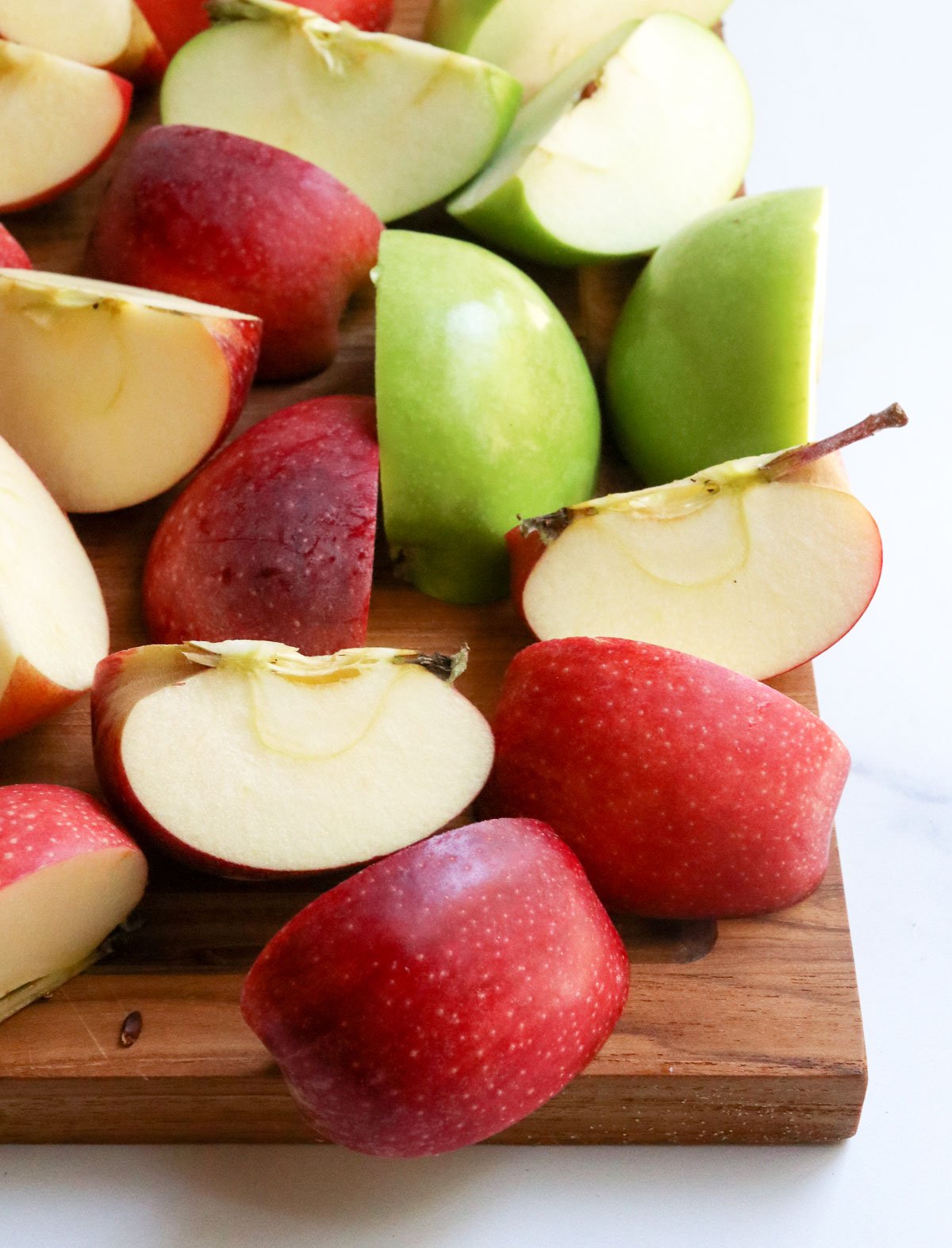 quartered apples on cutting board