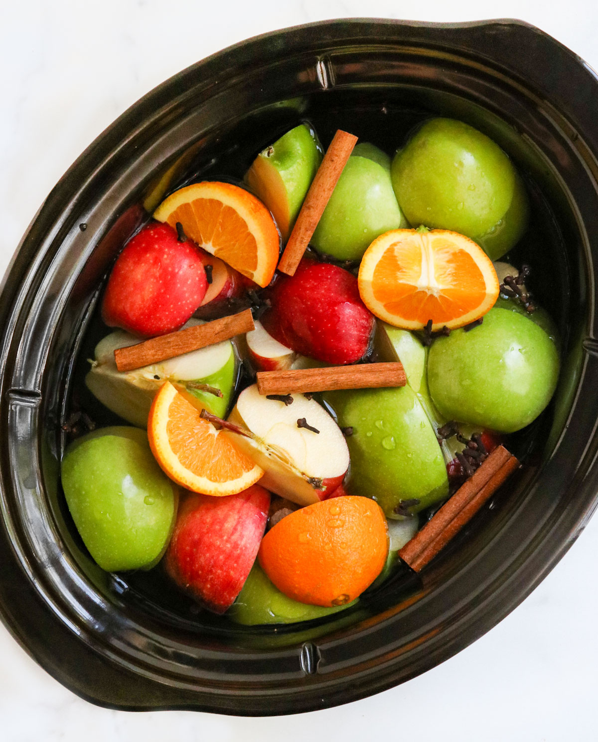 apples and oranges in slow cooker bowl