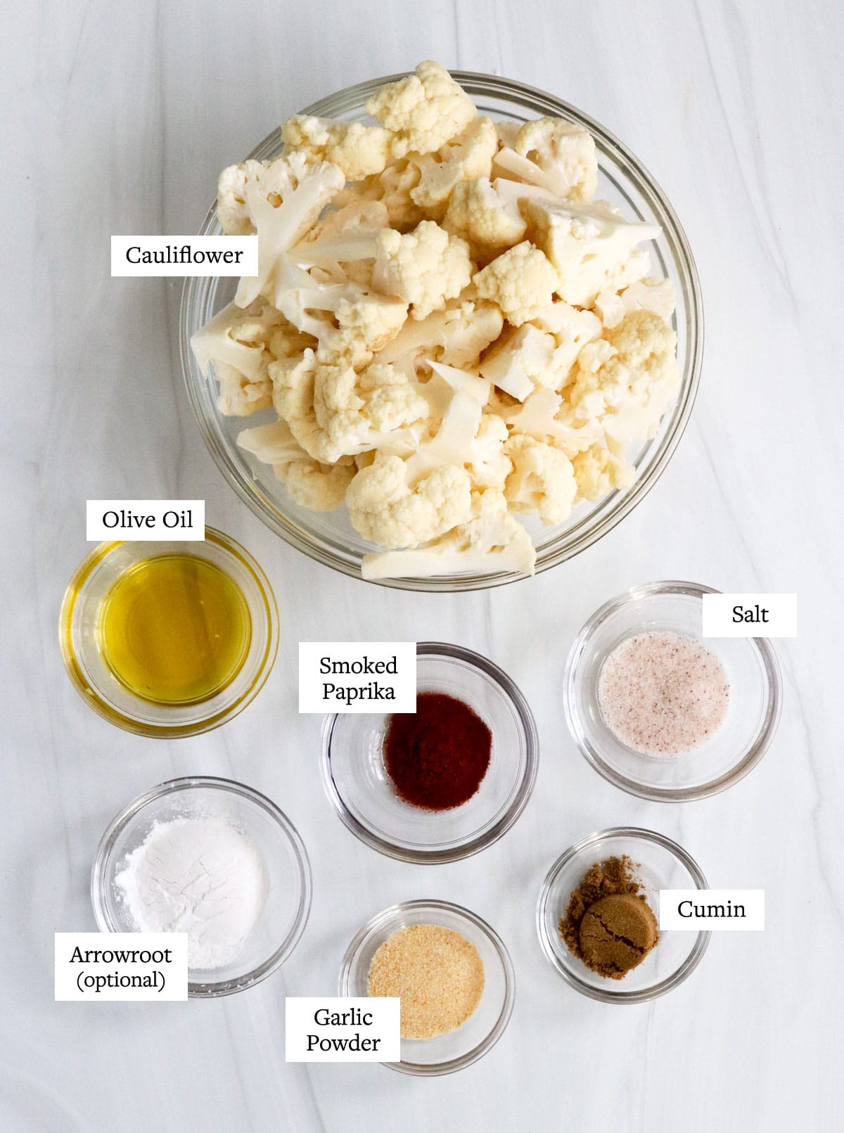 cauliflower taco ingredients in glass bowls on white surface