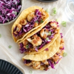 cauliflower tacos on parchment paper with purple slaw