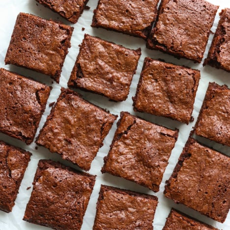 oat flour brownies sliced into 16 squares on parchment paper.