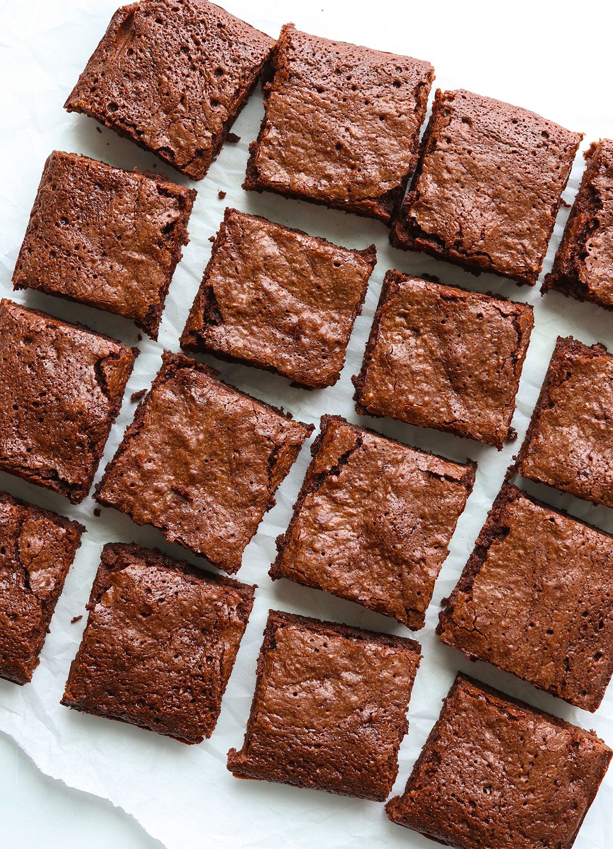 oat flour brownies sliced into 16 squares on parchment paper.