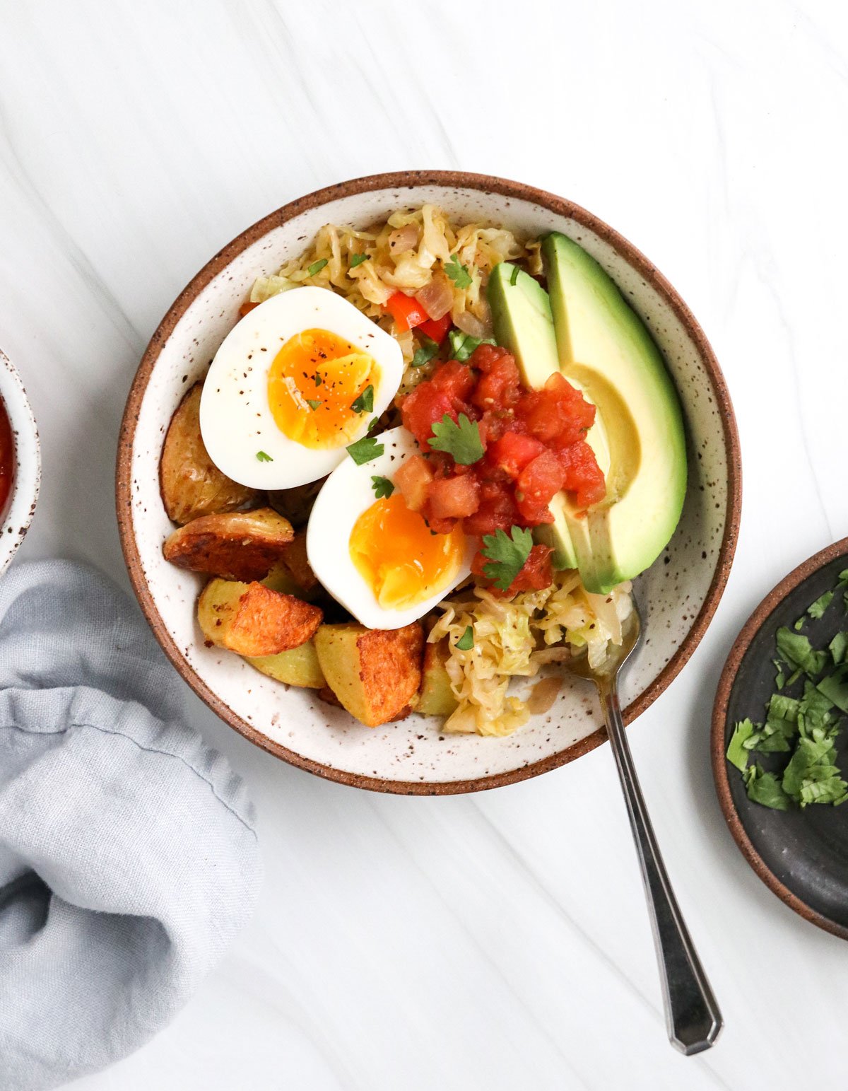 breakfast bowl topped with egg salsa and avocado