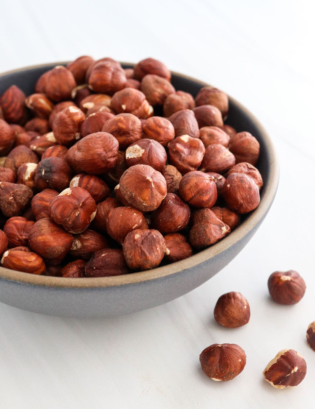 hazelnuts in a dark bowl.