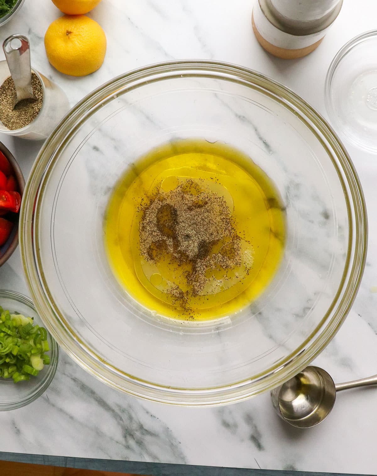 lemon and olive oil added to a large glass bowl.