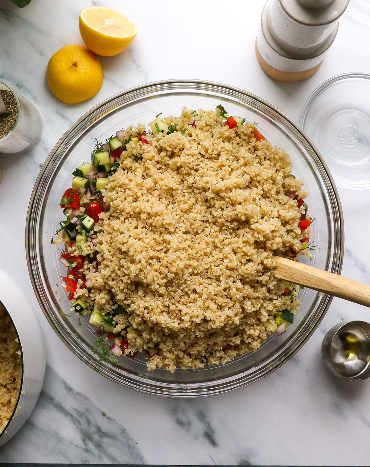 quinoa added to the large bowl of veggies to stir into the salad.