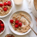 two bowls of quinoa porridge topped with raspberries and milk.