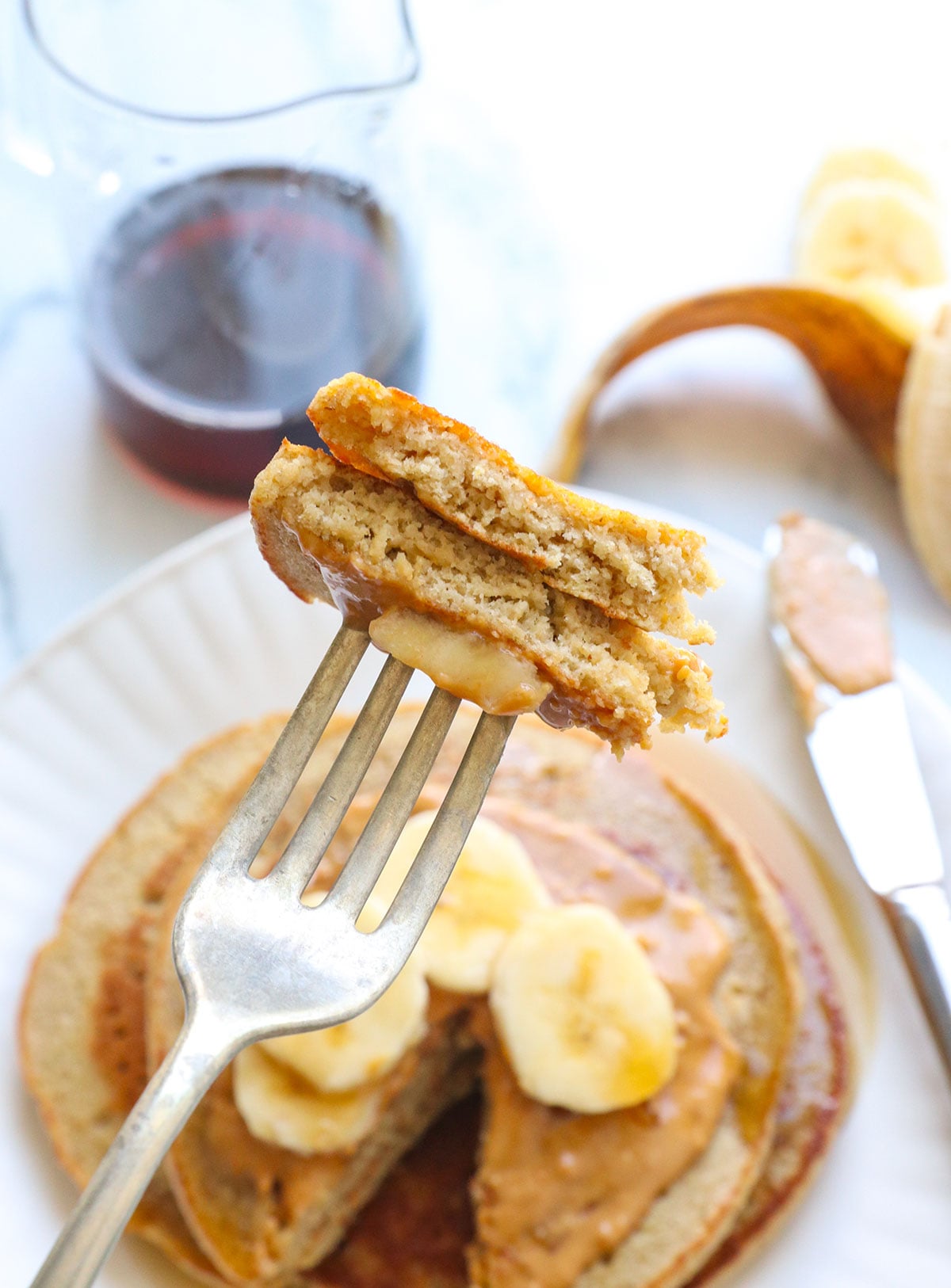 banana oatmeal pancakes lifted up as a bite on a fork. 