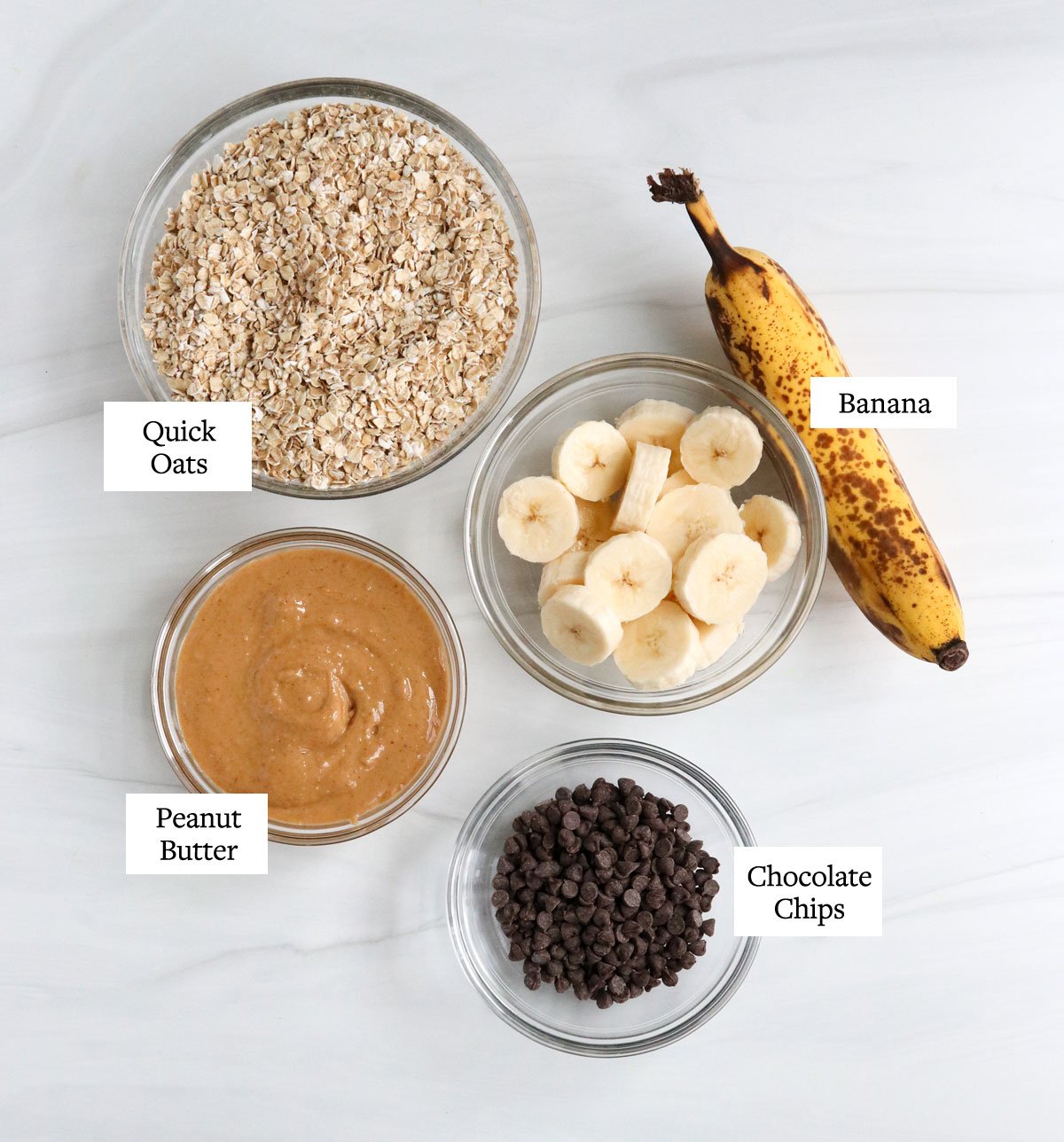 banana oatmeal cookies ingredients on white surface.