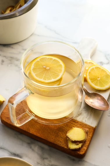 lemon slices in a glass mug of ginger tea.