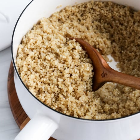 cooked quinoa with wooden spoon for serving.