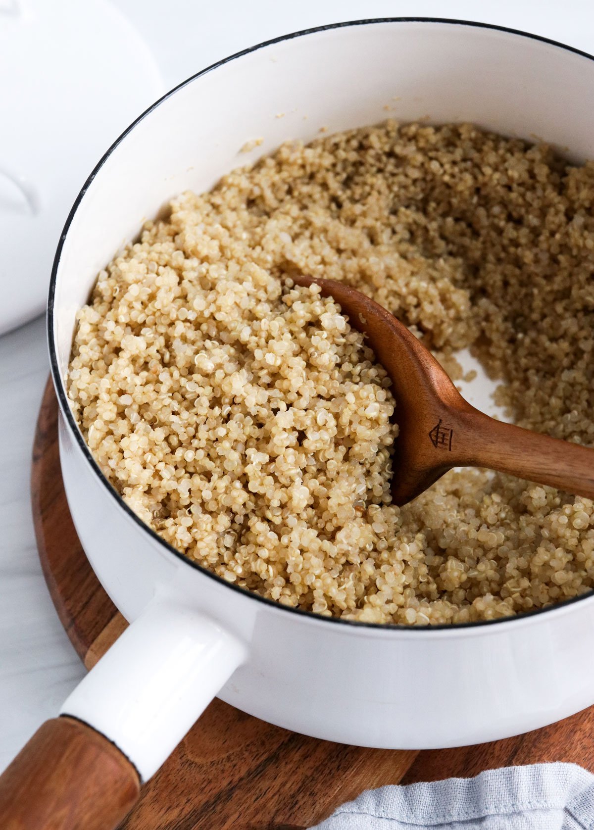 cooked quinoa with wooden spoon for serving.