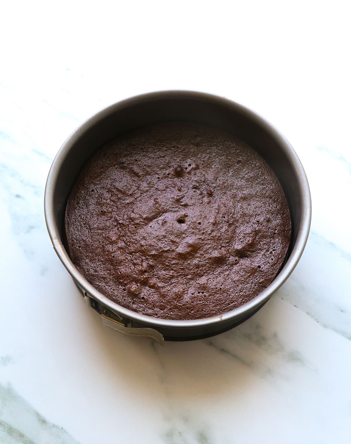 flourless chocolate cake cooling in a springform pan.