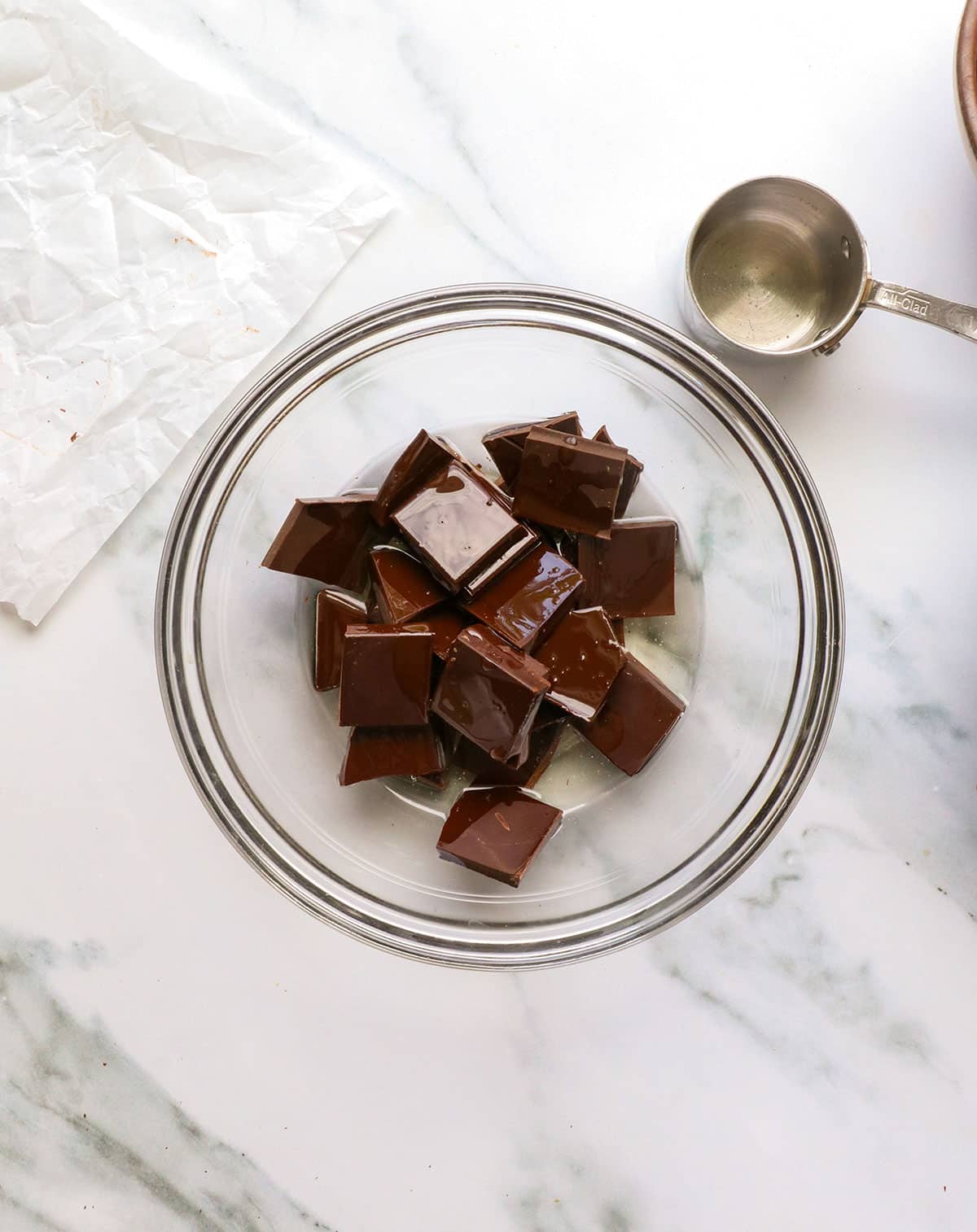 dark chocolate chunks and coconut oil added to a bowl.