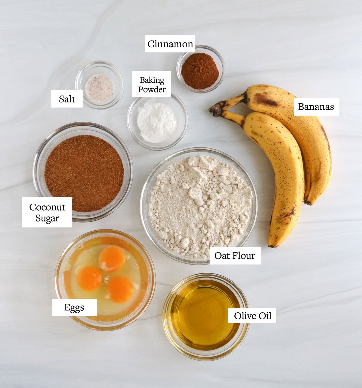 banana muffin ingredients on white surface.