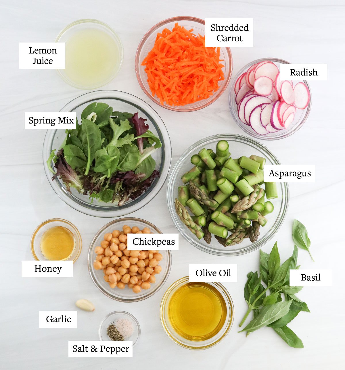 spring salad ingredients in glass bowls.