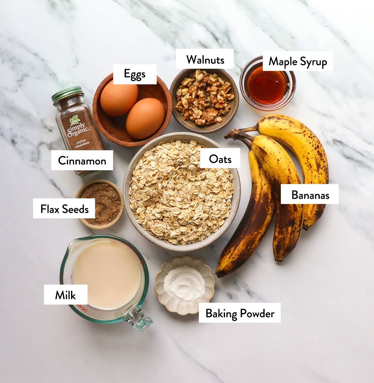 ripe bananas, eggs, oats, milk, and spices labeled in containers. 