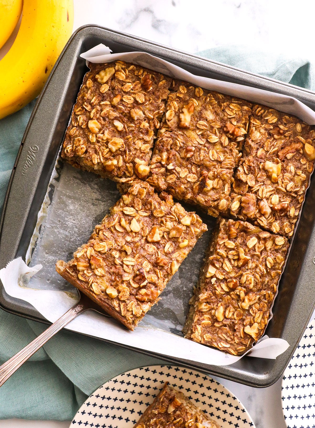 banana baked oatmeal cut into slices and served from a pan. 