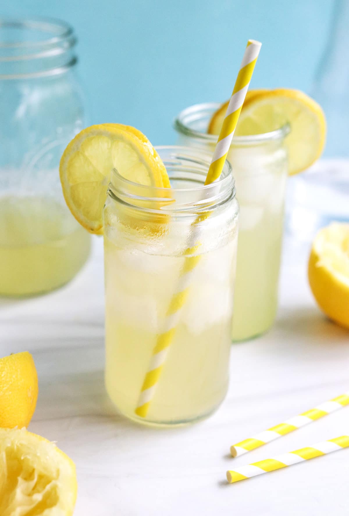 lemonade served with straws and garnished with lemon.