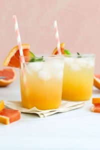 two mocktails in front of a peach background.