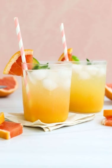 two mocktails in front of a peach background.