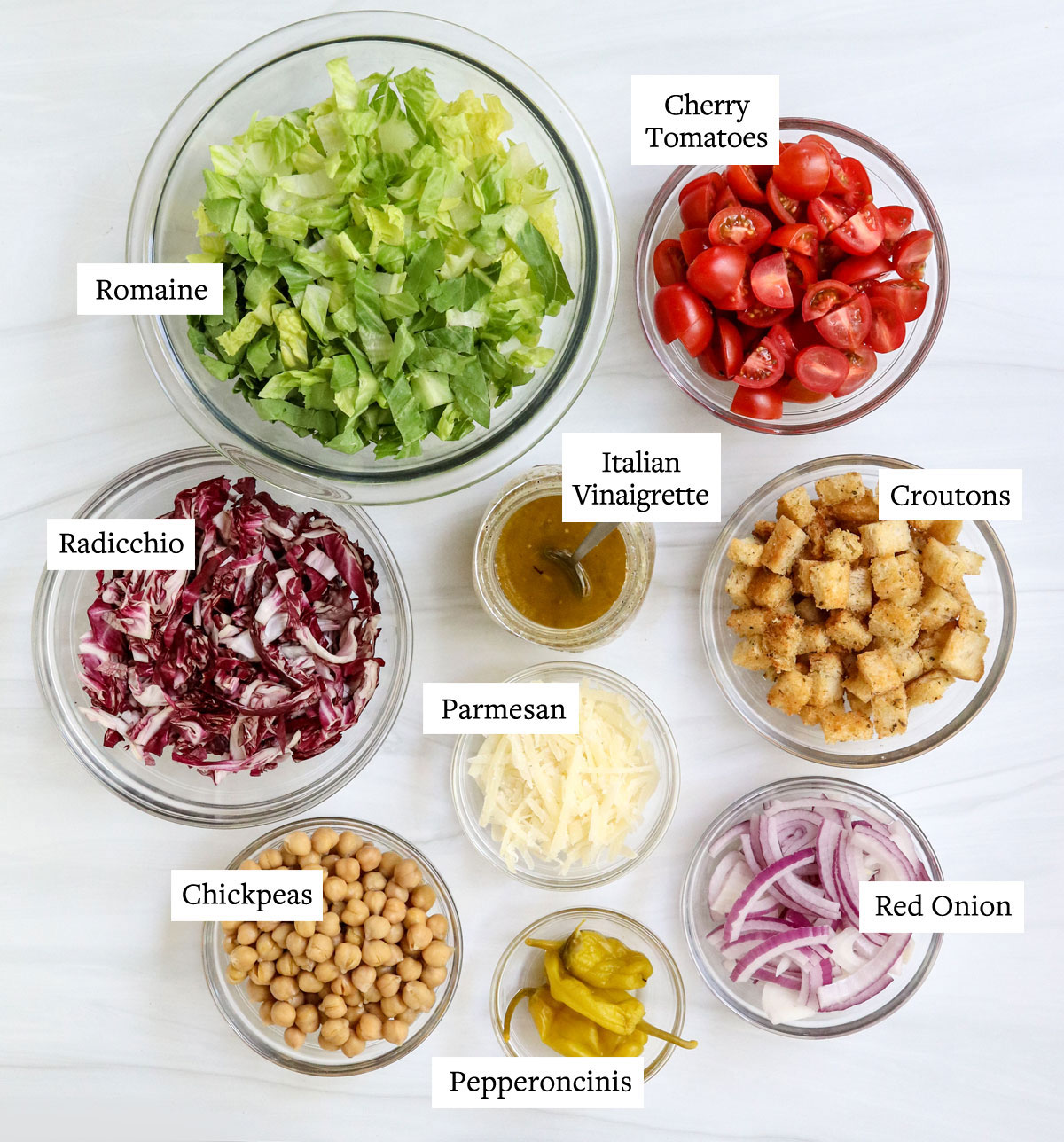 ingredienti dell'insalata italiana etichettati sulla superficie bianca.
