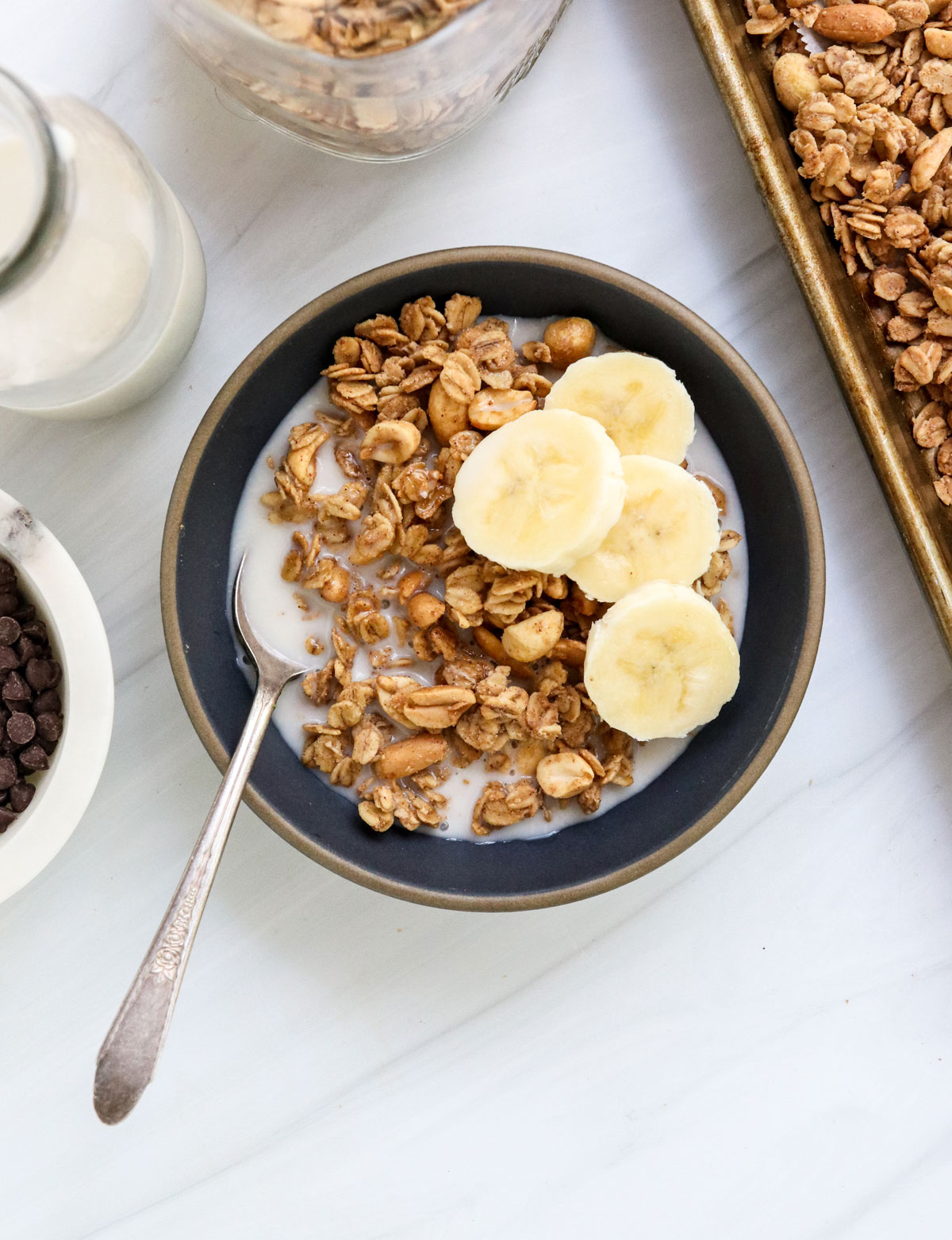 peanut butter granola served with milk and bananas.