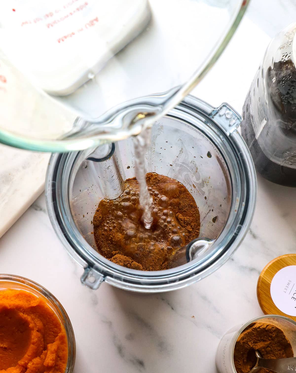 pumpkin puree, pumpkin pie spice, water, and almond butter added to a blender.