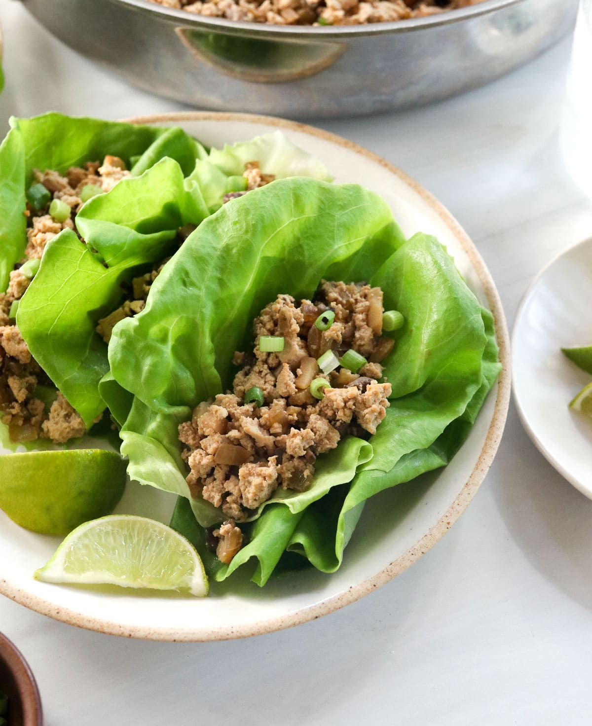 vegetarian lettuce wraps served with lime wedges.