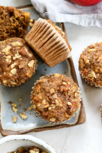 healthy apple muffins on blue plate with crushed walnuts.