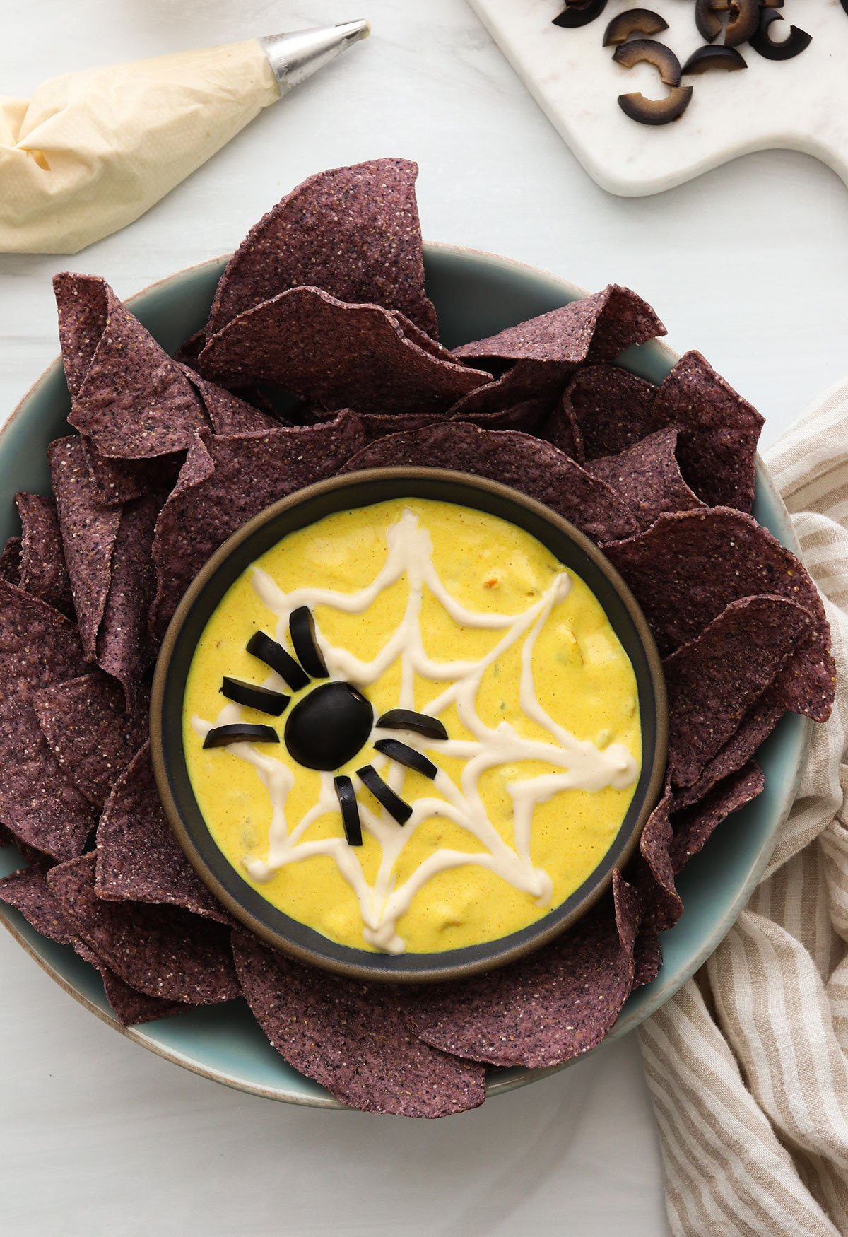 vegan queso with a spider web of sour cream on top.