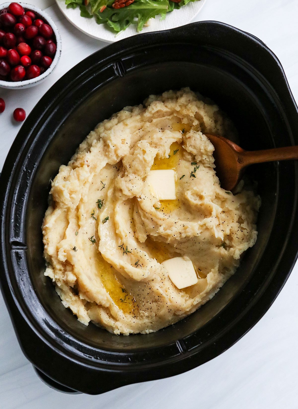 mashed potatoes served in slow cooker with butter on top.