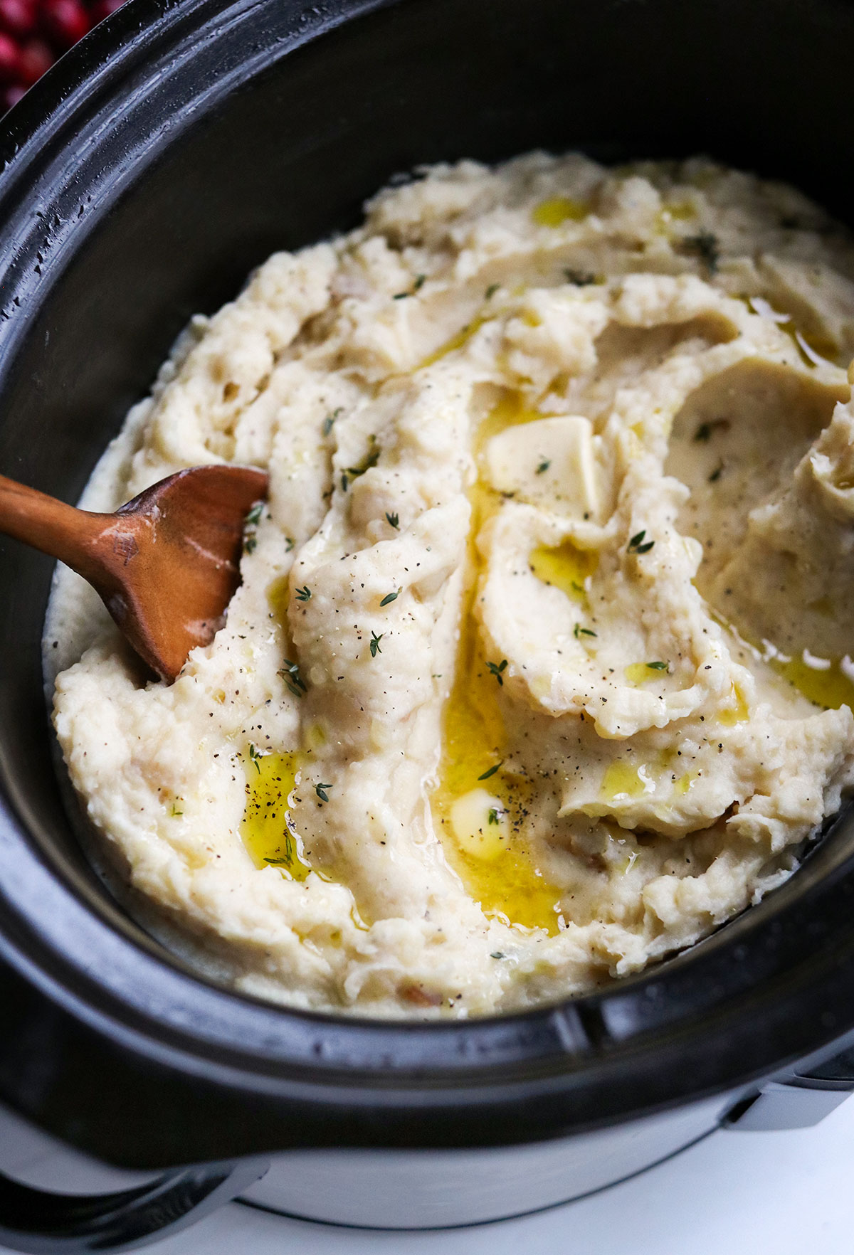 slow cooker mashed potatoes ready to serve with wooden spoon.