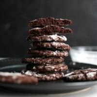 oat flour chocolate cookies stacked on black plate.