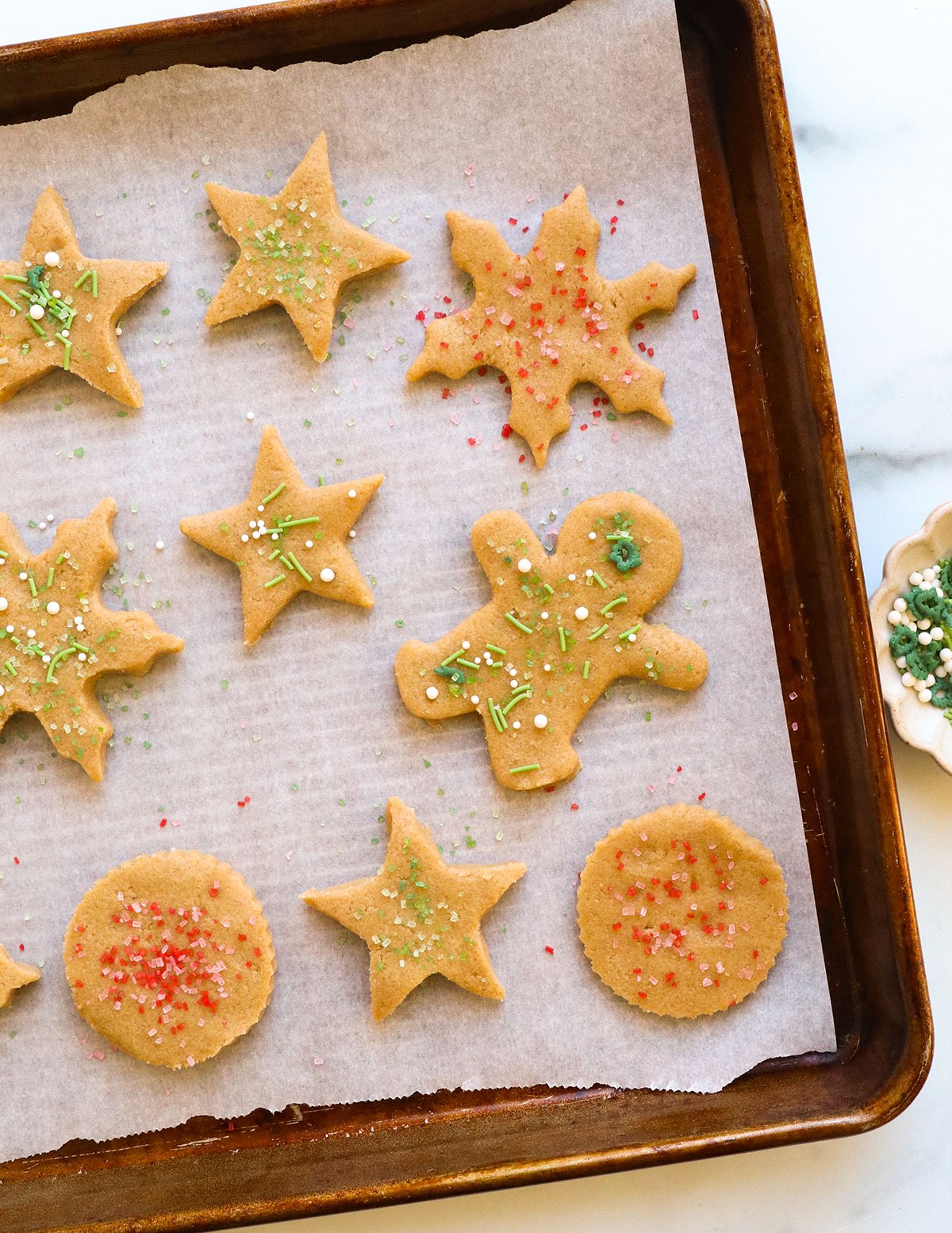 sprinkles added to raw cookie dough on a baking sheet.