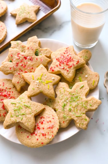 oat flour sugar cookies on a white plate topped with sprinkles.