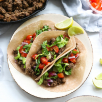 healthy tacos overhead on a plate with topping options.